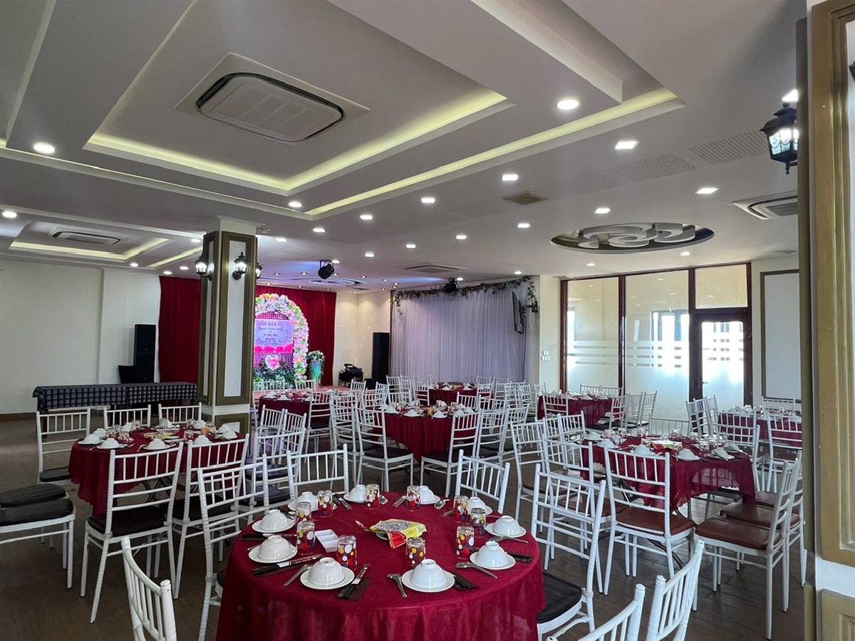 Sảnh tiệc bàn tròn khăn đỏ và sân khấu nhỏ